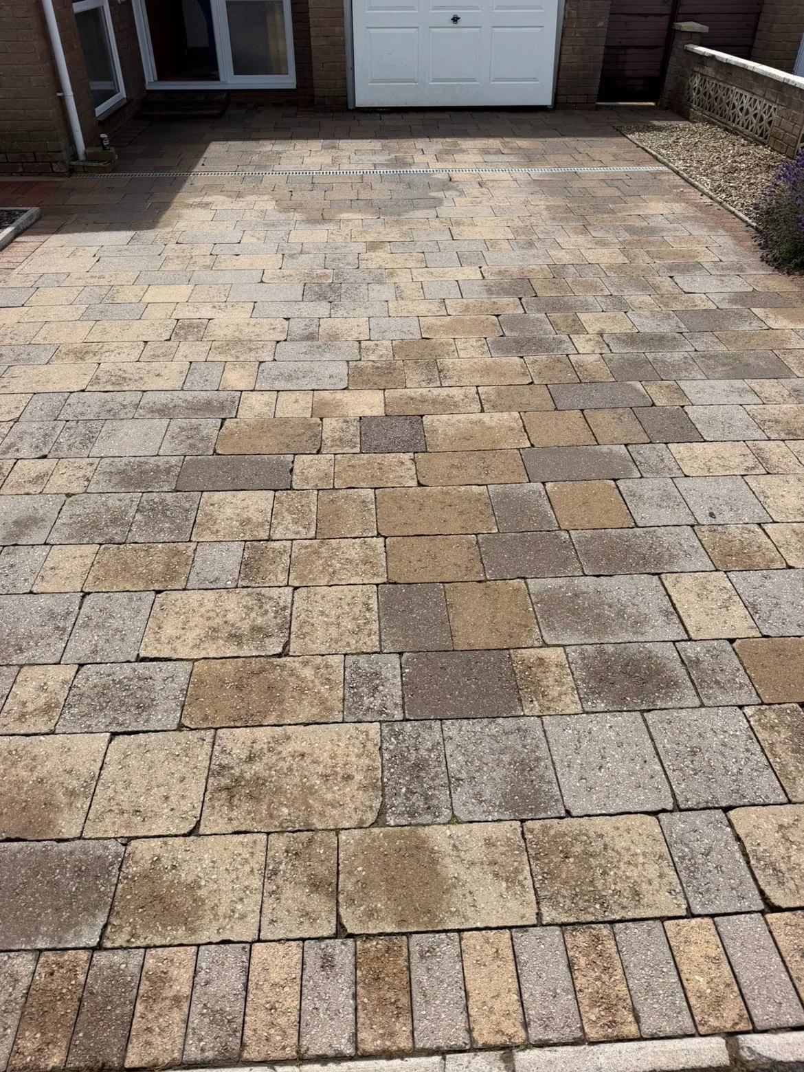 A mixed stone patio part way through cleaning